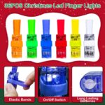 A hand wearing multiple colorful LED Christmas finger lights projecting festive images like Santa and snowmen in the dark.