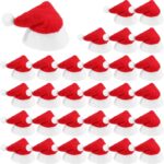 A close-up view of 30 small red and white Santa Claus hats, designed for decorating lollipops or small candies.