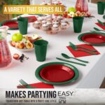 A complete set of red and green disposable party supplies, including dinner plates, appetizer plates, cups, napkins, and cutl