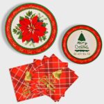 Red poinsettia patterned disposable dinner plates, dessert plates, and folded napkins for a Christmas party setting.