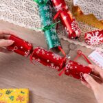 Eighteen red and green snowflake-themed no-snap Christmas party favors, each containing a crown, joke, and gift.
