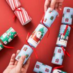Close-up of JOYIN 8-pack Christmas table favors in red and green, showing hats, jokes, and small gifts.