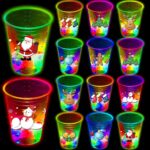 A set of 24 clear plastic 16oz mishunyus Christmas party cups with LED lights glowing, decorated with holiday stickers.