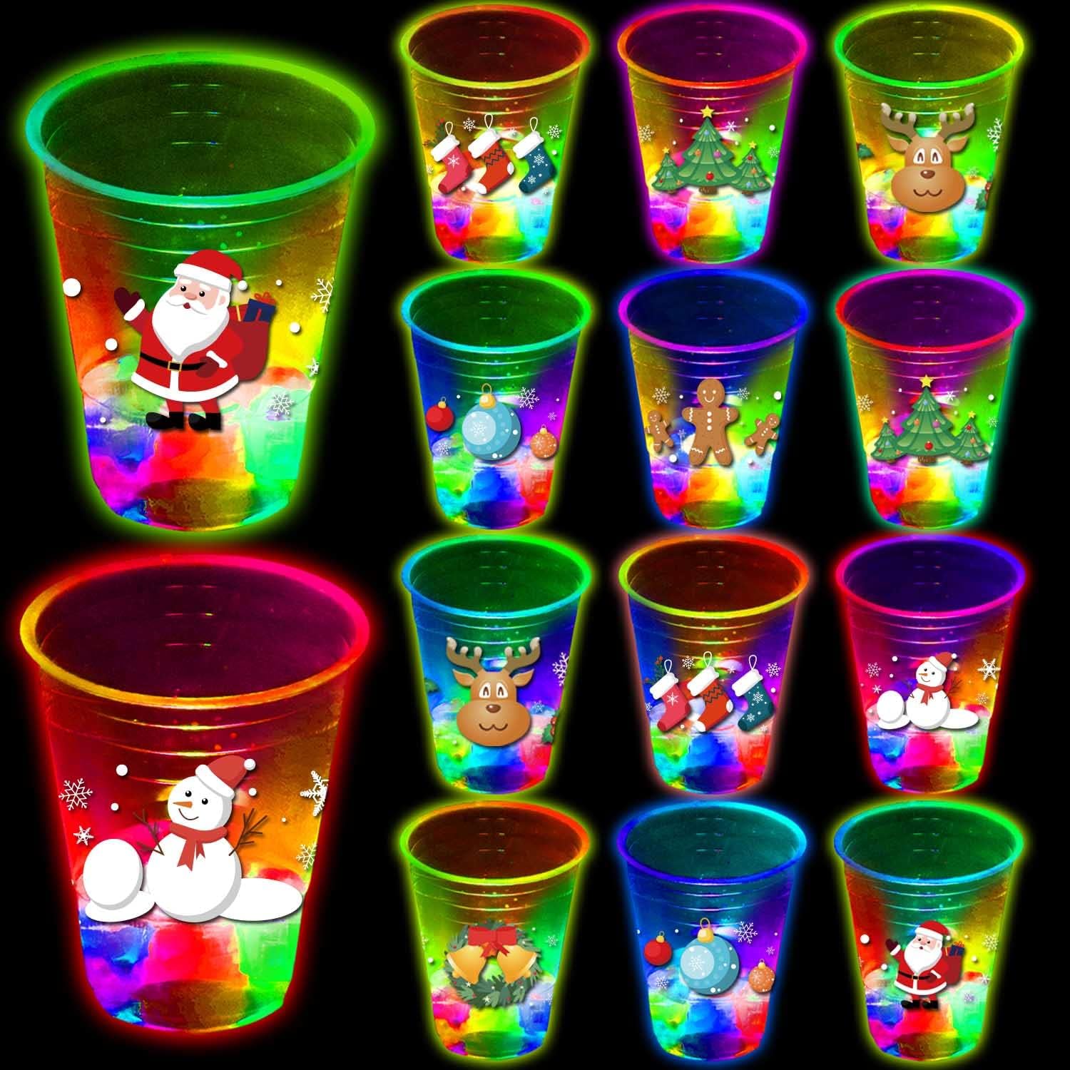 mishunyus-24-count-light-up-christmas-party-cups-16oz-holiday-theme-01 A set of 24 clear plastic 16oz mishunyus Christmas party cups with LED lights glowing, decorated with holiday stickers.