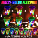 A set of 24 clear plastic 16oz mishunyus Christmas party cups with LED lights glowing, decorated with holiday stickers.