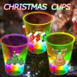 A set of 24 clear plastic 16oz mishunyus Christmas party cups with LED lights glowing, decorated with holiday stickers.