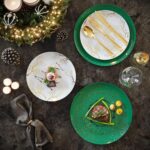 A stack of green disposable dinner plates with a subtle floral pattern, beside a stack of matching smaller dessert plates.