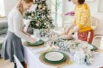 A stack of green disposable dinner plates with a subtle floral pattern, beside a stack of matching smaller dessert plates.