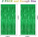 Two shimmering green metallic foil fringe curtains hanging, ready for a party backdrop or festive decoration.