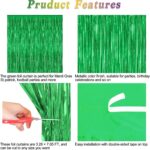 Two shimmering green metallic foil fringe curtains hanging, ready for a party backdrop or festive decoration.
